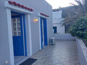 a white building with blue doors and a courtyard at Margarita's Home in Steniaí
