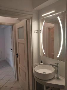 a white bathroom with a sink and a mirror at Margarita's Home in Steniaí +16 photos