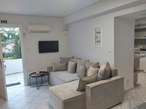 a living room with a couch and a tv at Margarita's Home in Steniaí