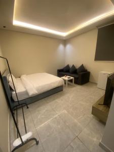 a bedroom with a bed and a couch in a room at Condo in Alramal near to the airport in Riyadh