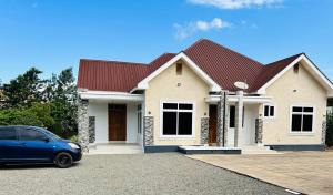 a house with a car parked in front of it at Hazina Homes in Boma la Ngombe