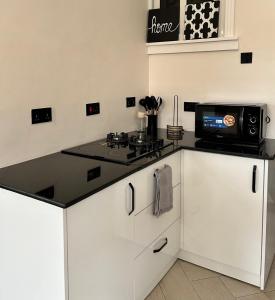 a kitchen with a counter with a stove and a microwave at Hazina Homes in Boma la Ngombe +18 photos