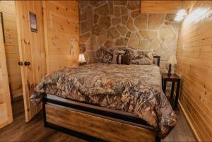a bed in a room with a stone wall at The Rustic Charm in Sevierville