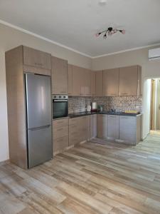 a kitchen with wooden cabinets and a stainless steel refrigerator at Apartment Belle Epoque in Lixouri +12 photos