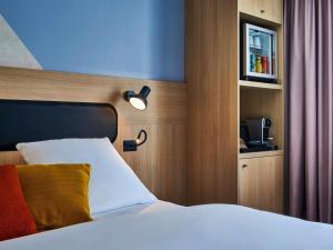 a bedroom with a bed with a light on the headboard at Mercure Paris Gare De Lyon TGV in Paris +102 photos