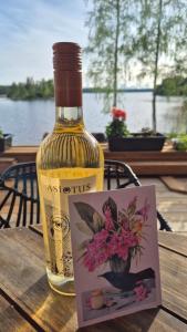 a bottle of wine sitting on a table with a card at Sauna by Lake Saimaa in Savonlinna