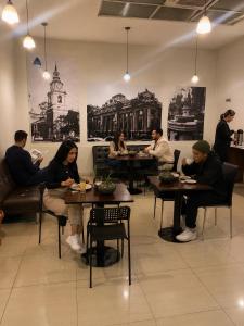 a group of people sitting at tables in a restaurant at Origen Apart-Hotel in Santiago