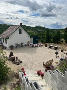 a large yard with a white building and tables and chairs at Kőlépcsős Vendégház in Nyúl
