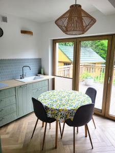 a kitchen with a table and chairs and a sink at Slow Life Rabka in Rabka-Zdrój