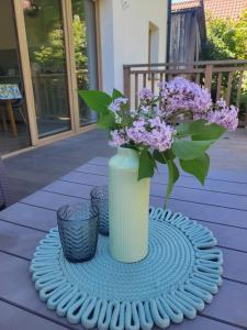 a white vase with purple flowers on a table at Slow Life Rabka in Rabka-Zdrój +29 photos