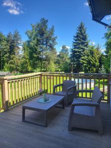 a deck with two chairs and a table on a deck at Slow Life Rabka in Rabka-Zdrój