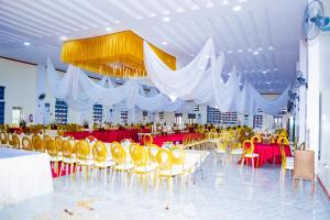 a large banquet hall with tables and yellow chairs at Ramlat Service Apartment in Ilorin