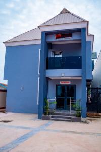 a blue building with a red sign on it at Ramlat Service Apartment in Ilorin