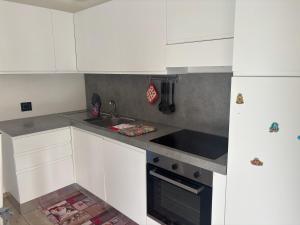 a kitchen with white cabinets and a sink at Villetta Col Ranzola in Brusson