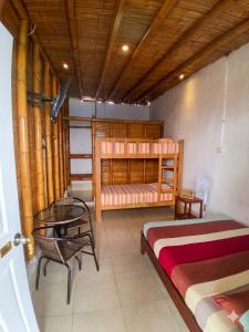 a bedroom with a bed and a table and a bed and a desk at Sumarfe in Máncora
