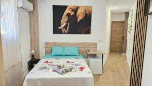 a bedroom with a bed and a picture of an elephant at Golden Tower Rooms - auto check-in in Gandía
