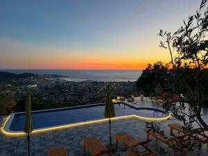 a pool with chairs and a sunset in the background at Ranc Mujica in Bar