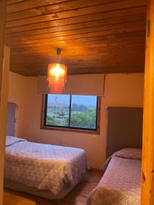 a bedroom with two beds and a window at Casa punta de lobos in Pichilemu