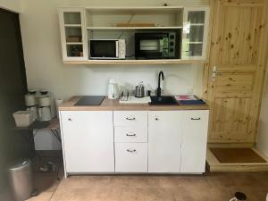 a kitchen with white cabinets and a microwave at SAAL am Pfarrhaus in Penzlin +5 photos