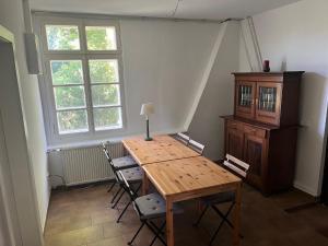a room with a wooden table and chairs and a window at SAAL am Pfarrhaus in Penzlin