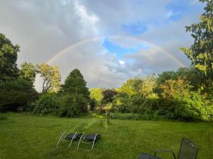 a rainbow in the sky with chairs in a field at SAAL am Pfarrhaus in Penzlin