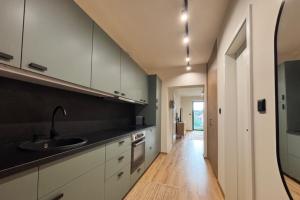 a kitchen with white cabinets and a sink at Andrea Apartman in Alsóörs