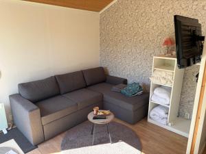 a living room with a couch and a table at Söt liten stuga för 2 in Strömstad