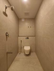 a small bathroom with a toilet and a shower at Arthana Grand Inn in Udumalaippettai