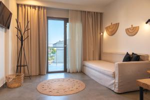 ein Wohnzimmer mit Sofa und Glasschiebetür in der Unterkunft Delight Suites in Limenaria