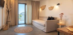 ein Wohnzimmer mit Sofa und Balkon in der Unterkunft Delight Suites in Limenaria