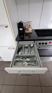 a kitchen with a stove with utensils in a drawer at Messe-Badische SBB- grosse Wohnung in Basel
