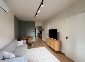 a living room with a couch and a tv and a table at Andrea Apartman in Alsóörs