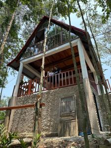 two people sitting on the balcony of a tree house at Cabaña Moyobamba in Moyobamba