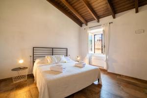 a bedroom with a large bed with towels on it at Sardinian Gallery Domus Historic Rooms & Apartments in Bosa +5 photos