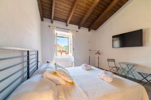 a bedroom with a bed with towels on it at Sardinian Gallery Domus Historic Rooms & Apartments in Bosa