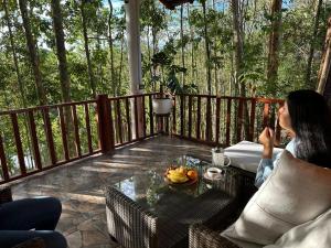 a woman sitting on a porch talking on a cell phone at Cabaña Moyobamba in Moyobamba