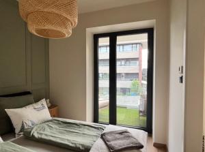 a bedroom with a bed and a large window at Andrea Apartman in Alsóörs