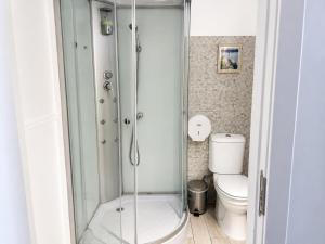 a bathroom with a toilet and a glass shower at Casa da Aida - Fuzeta in Fuzeta