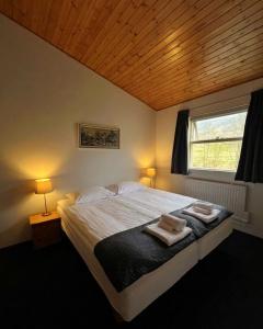 a bedroom with a bed with two towels on it at Engimyri Lodge in Akureyri