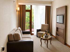 a living room with a couch and a chair and a table at Sputnik Hotel Batumi in Batumi