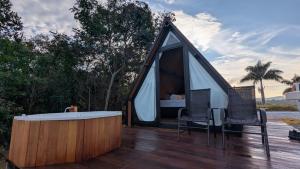 a tent with a hot tub on a deck with two chairs at Chalé Suiço Diniz e Ferreira in Contagem