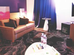 a living room with a couch and a table at ibis Styles Arles Palais des Congrès in Arles
