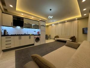 a living room with a couch and a tv and a kitchen at Alas Garden City Apartment Fethiye in Fethiye