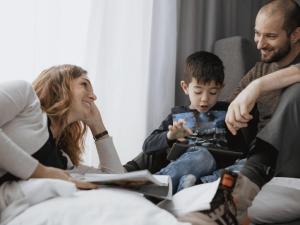 a family sitting on a couch playing with a tablet at ibis Berlin Dreilinden in Kleinmachnow +34 photos