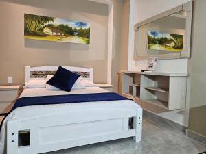 a bedroom with a white bed and a mirror at Hotel San Jeronimo Armenia in Armenia +77 photos