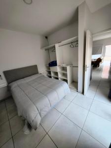 a bedroom with a bed and a tiled floor at Depto Civora 2 in Villa Regina