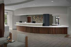 a lobby with a waiting area with two chairs and a counter at Courtyard by Marriott Carolina Beach Oceanfront in Carolina Beach