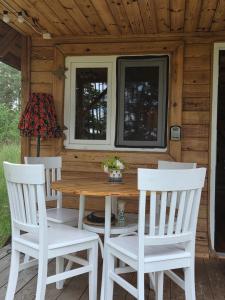 a wooden table and chairs in front of a cabin at Pod Czarnym Dzięciołem - dom z widokiem i prywatną balią in Mazówki +49 photos