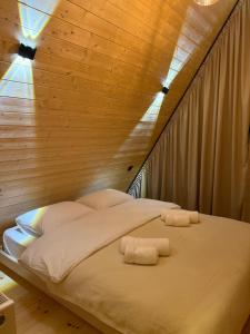 a bed in a room with two towels on it at Tera Cottages kazbegi in Kazbegi