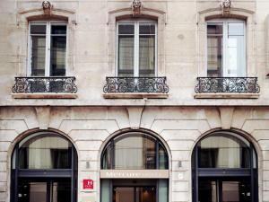a building with four arched windows on it at Mercure Lyon Centre Plaza République in Lyon